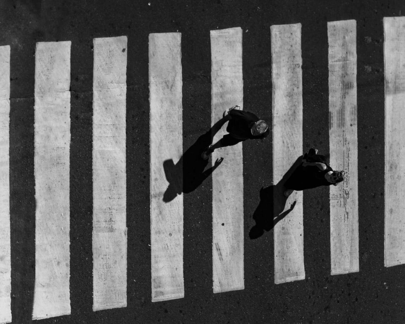 people on crosswalk in black and white